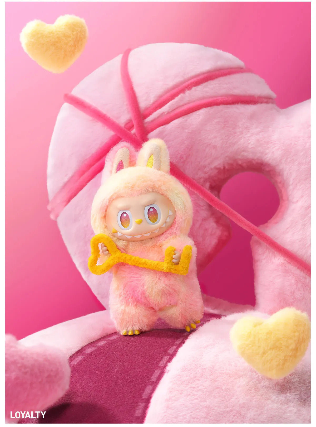 Cute plush toy with a key on a pink background