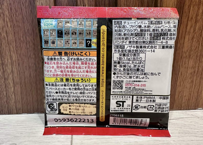 The back of a Japanese toy packaging blister pack for 'One Piece Chara-Mangets' by Bandai Namco, resting on a light wood floor against a dark wood panel background.