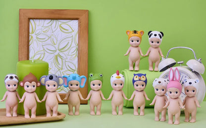 Row of baby figurines with colorful hats on a green background