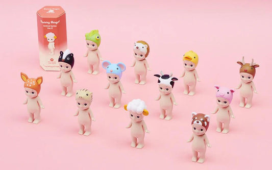 Set of small figurines with animal-themed hats on a pink background