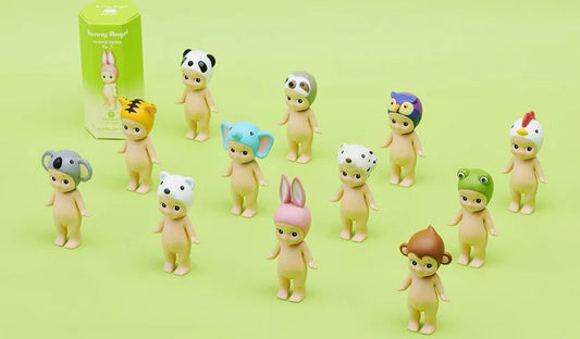 Set of Sonny Angel Series 1 baby figurines with animal-themed hats on a green background